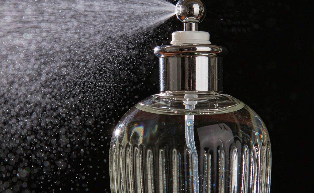 Perfume spray pump output test showing fine mist from a glass perfume bottle atomizer