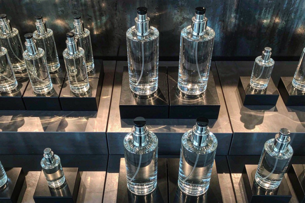 Perfume bottles of different heights arranged on a luxury retail fragrance shelf