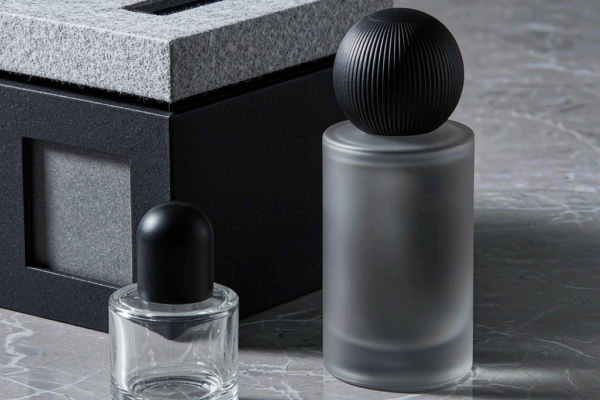 Gender-neutral fragrance packaging with minimalist glass perfume bottles in neutral tones