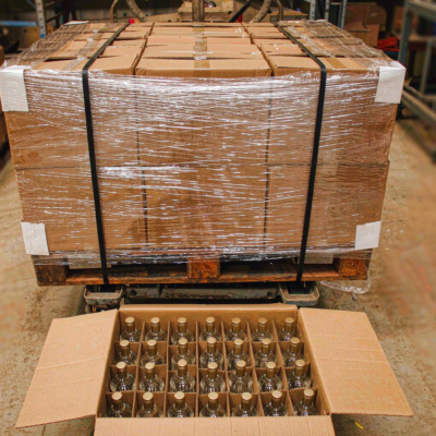 Wrapped export pallet of corrugated cartons and an open carton with divider grid holding glass perfume bottles