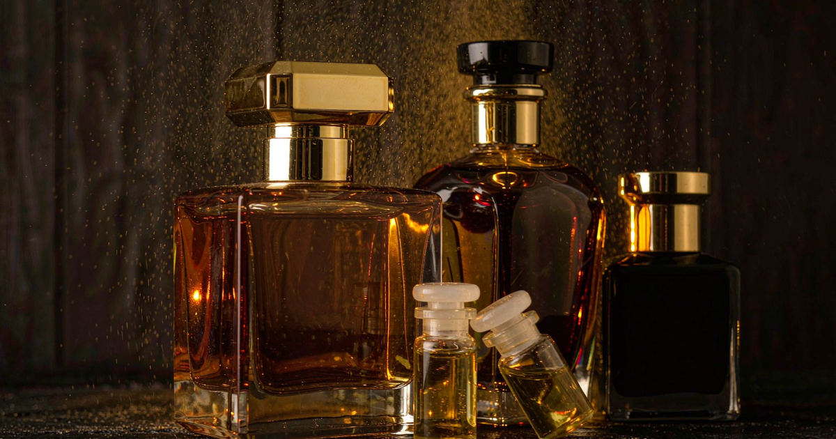 A group of premium Middle Eastern style perfume bottles including a faceted amber flacon with gold collar and small attar vials with glass stoppers