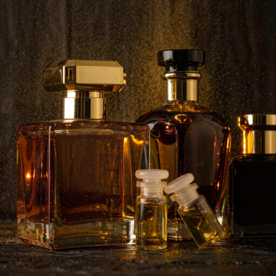 A group of premium Middle Eastern style perfume bottles including a faceted amber flacon with gold collar and small attar vials with glass stoppers