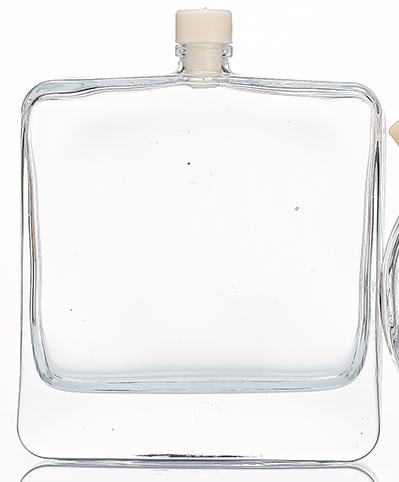 100 ml clear glass perfume bottle with wide flat flask body, rounded corners and flat front panel, shown with a small plug cap