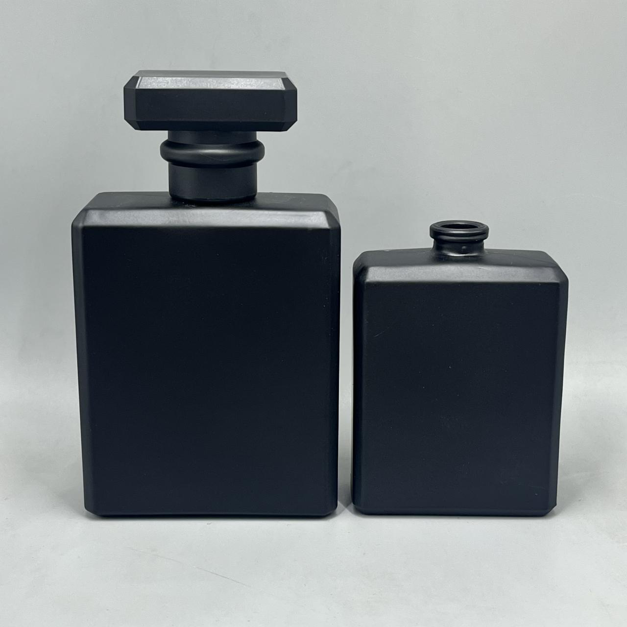 30 ml glass perfume bottle in a squat rectangular flask shape with rounded corners, matte black spray coating and a black cube overcap